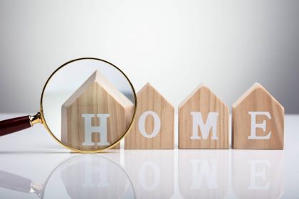 Magnifying,Glass,In,Front,Of,Wooden,House,Model,Arranged,In HOA insurance